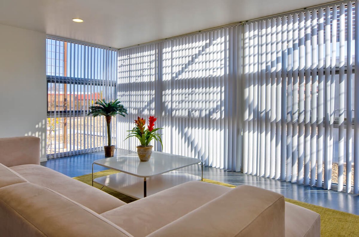 Sunlit community great room at Lolomas with lounge seating and floor-to-ceiling windows